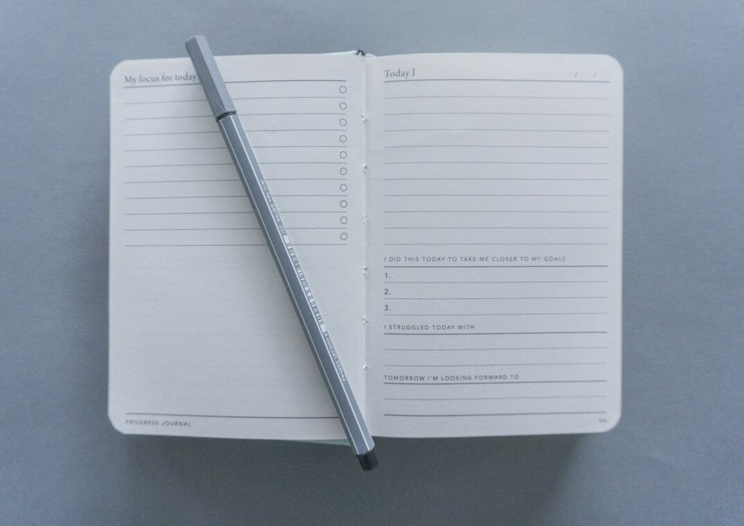 Open notebook with a breathing exercise diagram and a pen