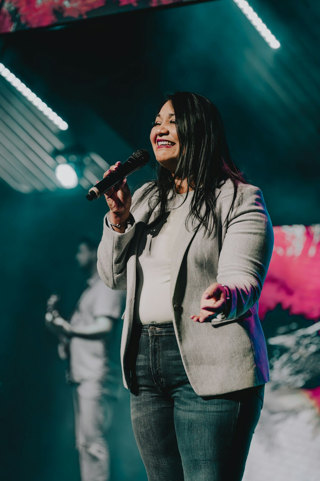Woman confidently speaking into a microphone during a voice training session